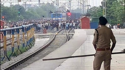 Police personnel chase aspirants of the Bihar Police Prohibition Department recruitment examination at the Pataliputra Railway Station in Patna on Sunday. (HT Photo)